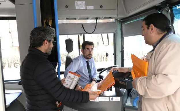 Una de las candidaturas entrega propaganda a un conductor de Auvasa. 