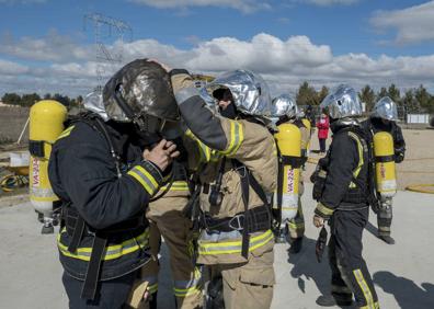 Imagen secundaria 1 - El contenedor contiene una zona de combustión sobreelevada para controlar los gases. Bajo ella se ha colocado ladrillo refractario para que la instalación aguante más tiempo, ya que se alcanzan temperaturas de casi 600º. Colocarse bien el equipamiento es clave, porque la simulación, aunque controlada, es con fuego real. A la derecha, momento en que el instructor explica cómo comienza el fuego. Se pretende que sepan distinguir las diferentes fases por las que evoluciona un incendio desde su inicio.