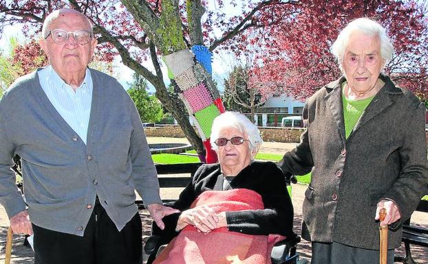 Juan (100 años), Librada (105) y Gregoria (104), en los jardines de la residencia de Cáritas en El Sotillo. 