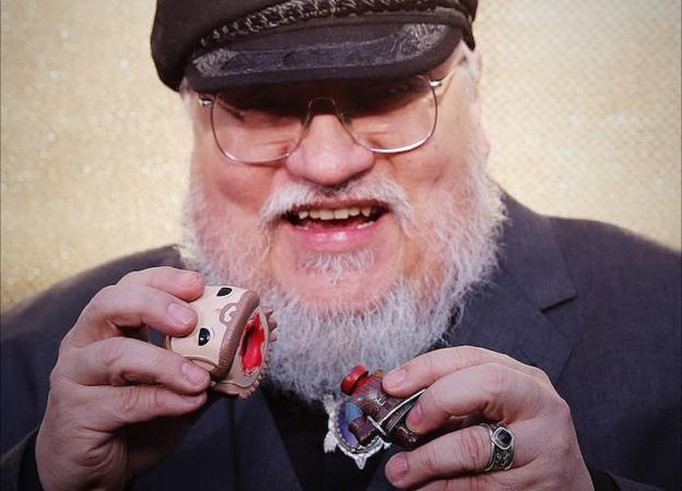 George R.R. Martin descabeza un muñeco Funko de Juego de Tronos en una imagen extraída de la cuenta oficial de Instagram de la serie. 