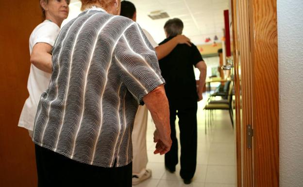 Unos ancianos reciben ayuda en una residencia. 