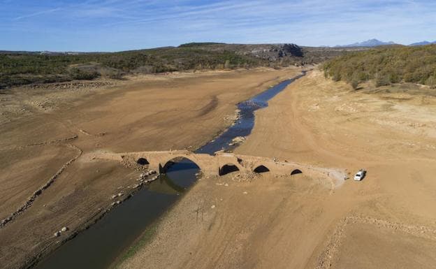La bajada del nivel de las aguas a causa de la sequía en el embalse de Aguilar de Campoo, deja al descubierto el puente medieval del siglo XIII del pueblo de Villanueva del Río. 