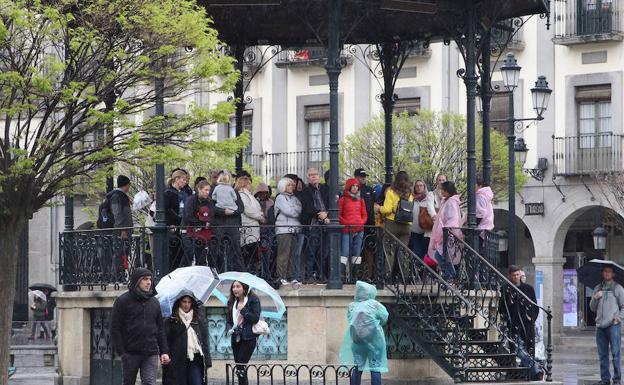 Grupos de visitantes se refugian en el templete de la Plaza Mayor.