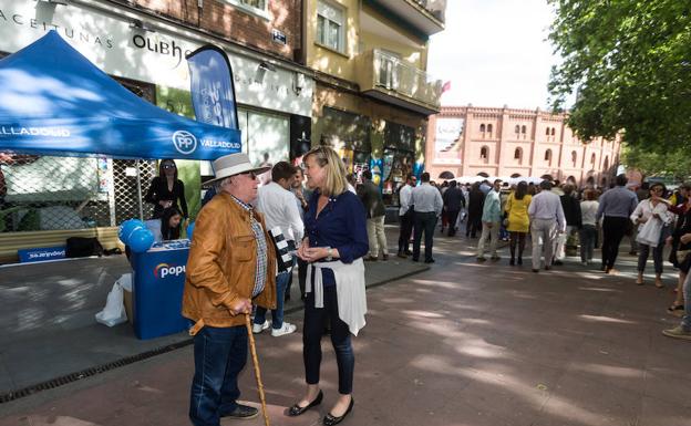 La cabeza de lista del PP al Ayuntamiento de Valladolid, Pilar del Olmo, charla con un aficionado en la caseta que se situó junto a la plaza de toros. 