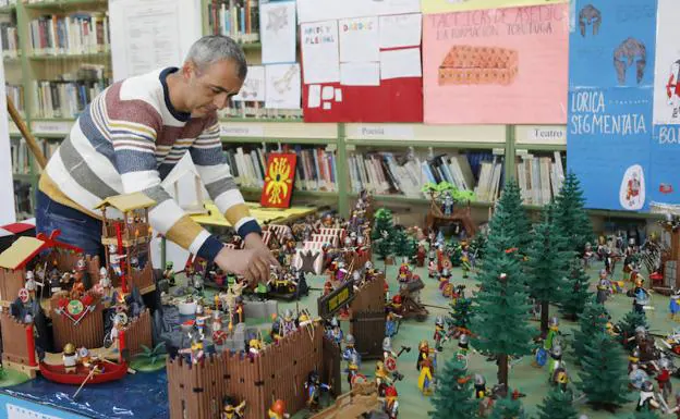 El profesor David Garrido coloca una figura en la exposición de playmobil. 