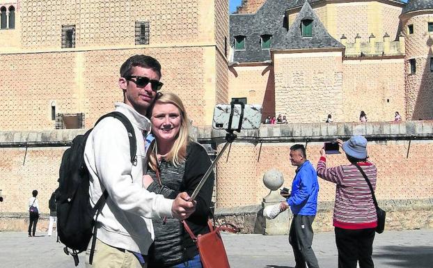 Una pareja se hace un 'selfie' frente al Alcázar de Segovia. 