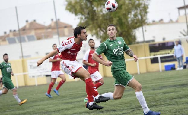 Un jugador del Churra, a la derecha, pelea un balón en el Municipal de Churra. 