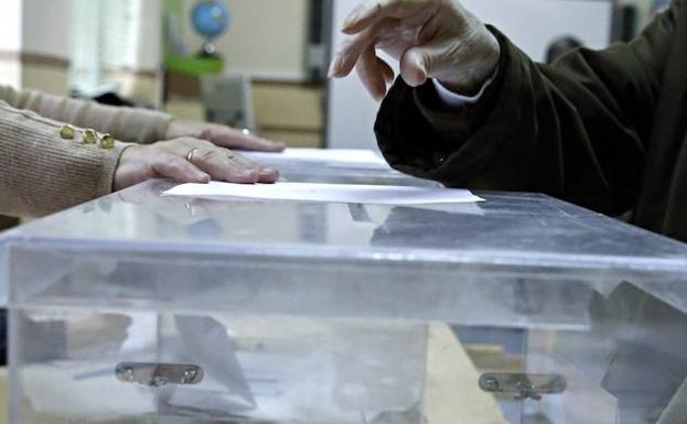 Una mujer deposita su voto. 