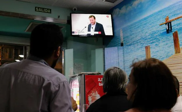 Alberto Bustos y María Sánchez siguen por televisión las declaraciones de Óscar Puente en la noche electoral. 