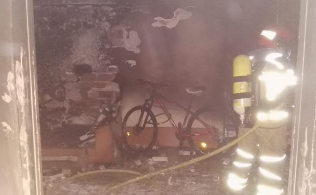 Los bomberos extinguen las llamas en la vivienda.