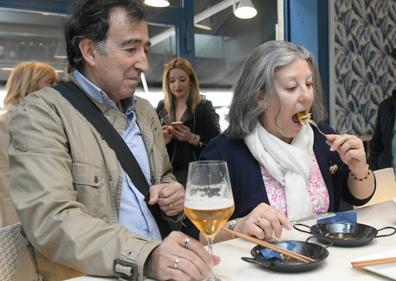 Imagen secundaria 1 - Arriba, tres clientes a las puertas de uno de los bares participantes en el certamen. Abajo a la izquierda, Están dispuestos a probar más de una tapa estos días. A la derecha a punto de hincarle el diente a una de las tapas. 