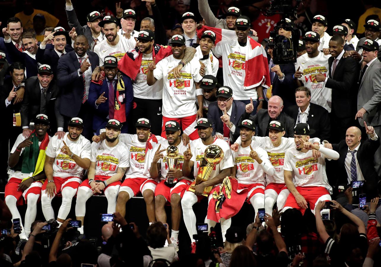 Kawhi Leonard, con el trofeo de MVP, y Serge Ibaka, con el de la NBA, junto al resto de la plantilla de los Raptors.