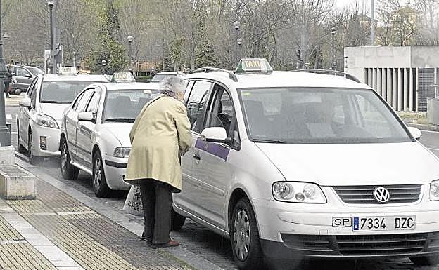 Una clienta se dispone a subir a un taxi en la parada de plaza Juan de Austria. 