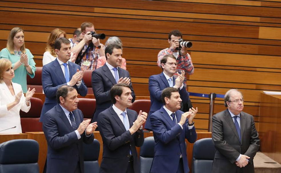 Juan Vicente Herrera, presidente en funciones de la Junta, mano sobre mano mientras los representantes del PP aplauden a Luis Fuentes como nuevo presidente de las Cortes. 