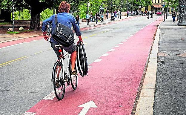 Un ciclista pedalea por un carril bici.