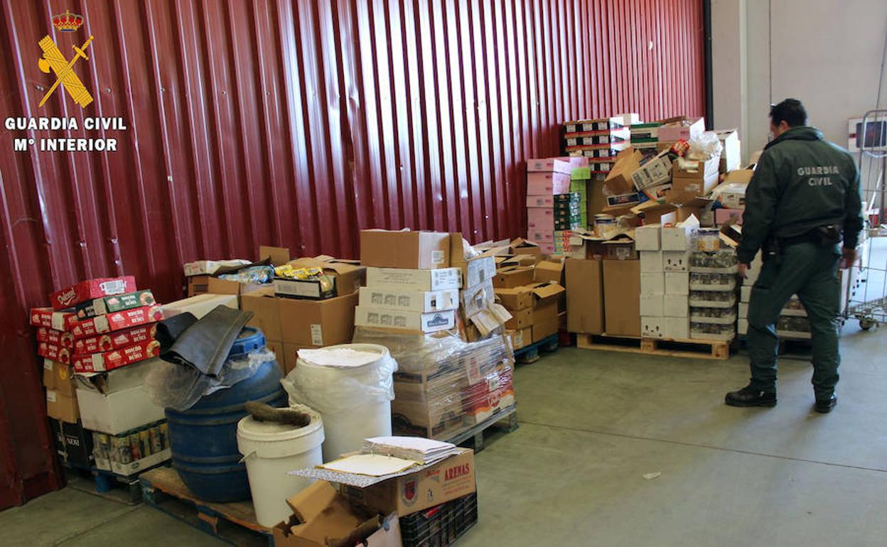 Un guardia civil observa los productos alimenticios intervenidos. El Norte