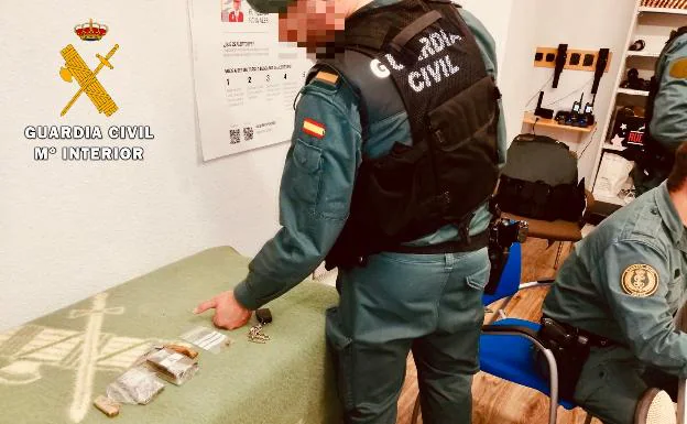 Un guardia civil revisando los objetos y estupefacientes incautados en El Barco de Ávila.