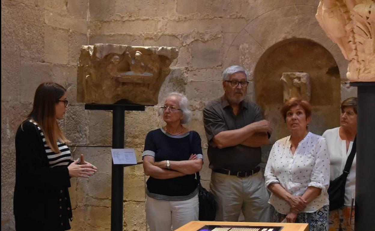 La guía Cristina Párbole explica los detalles de los capiteles a un grupo de visitantes. 