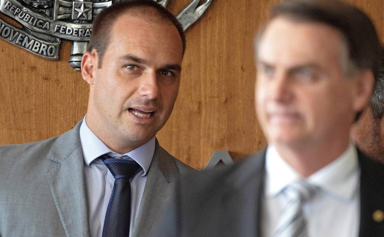 Fotografía de archivo fechada el 7 de noviembre de 2019 que muestra al diputado Eduardo Bolsonaro (i), hijo del presidente electo de Brasil, Jair Bolsonaro (d), mientras escucha a su padre durante una rueda de prensa. 