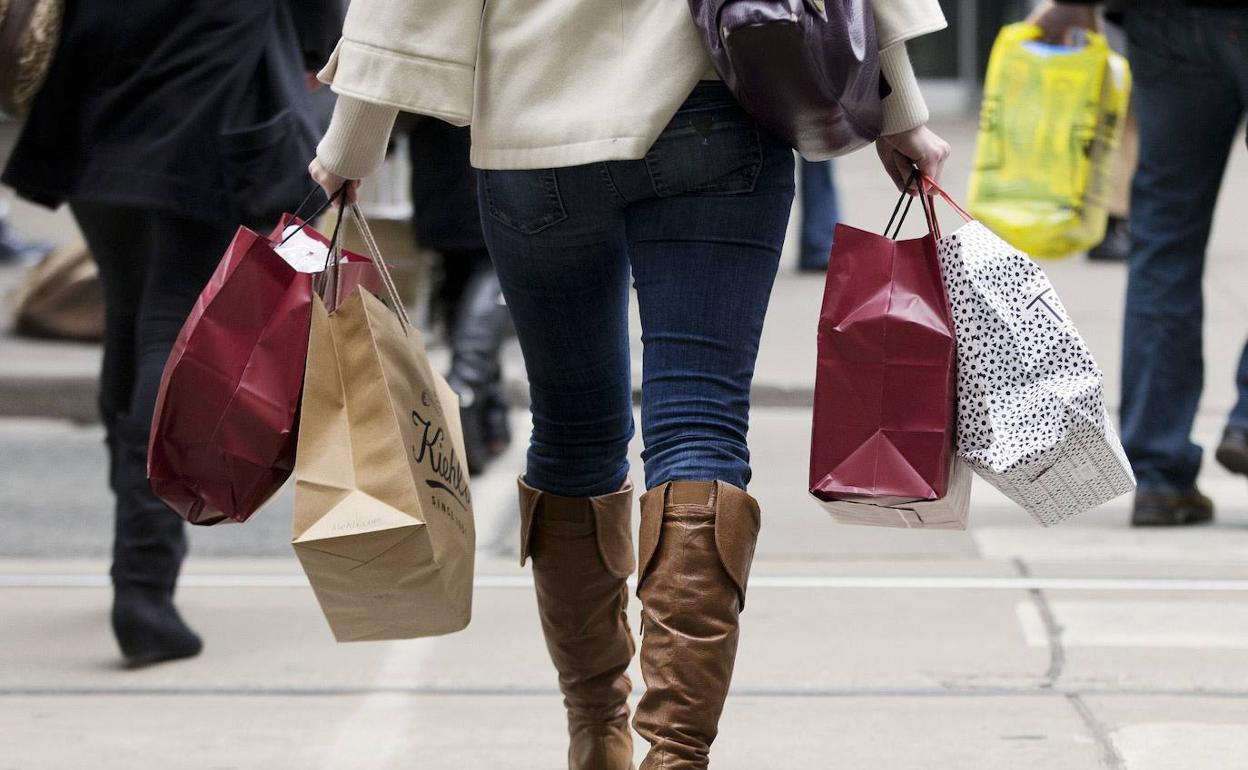 Una mujer acarrea varias bolsas con compras.