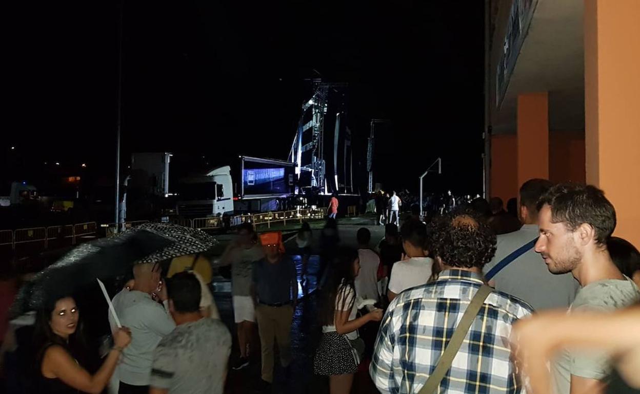 Asistentes a la verbena de Santa Marta, refugiados en los soportales por la lluvia que cayó a primera hora de la noche.