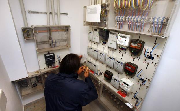 Un hombre revisa el cuadro de contadores eléctricos en una comunidad de vecinos.