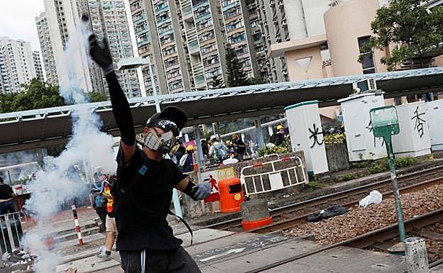 Un manifestante devuelve a la policía un bote de gas lacrimógeno durante las protestas.