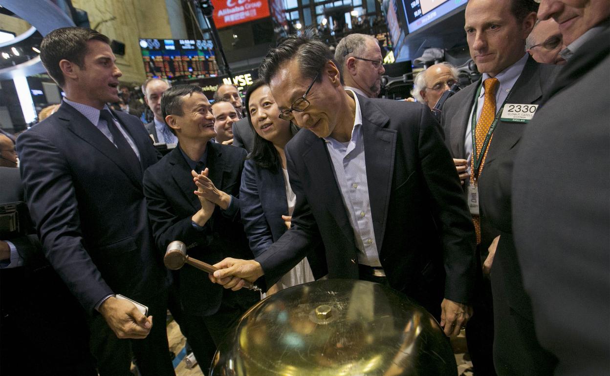 Joseph Tsai (c) toca la campana de la Bolsa de Nueva York.