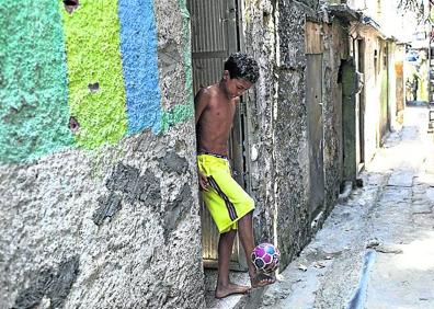 Imagen secundaria 1 - Postales.  Soldados brasileños patrullando por Rocinha. Un niño jugando al balón. Vista de la favela. 