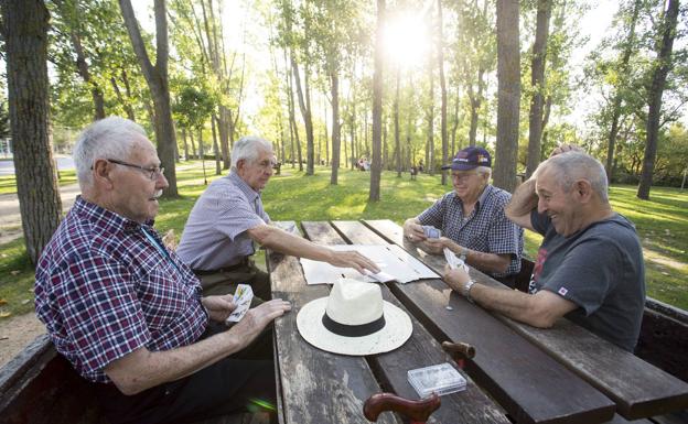 Un grupo de jubilados juega a las cartas. 