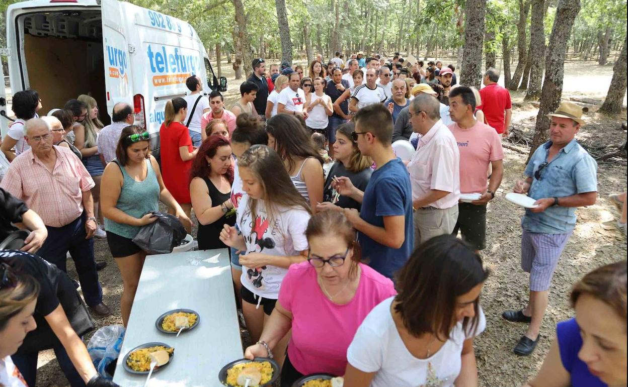 Los vecinos acercándose en fila para recoger su comida, en el merendero de La Dehesa.