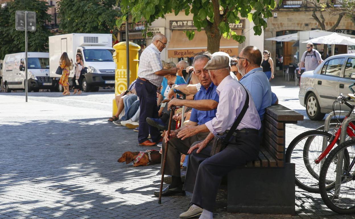 Un grupo de mayores descansa en unbanco de la capital salmantina.