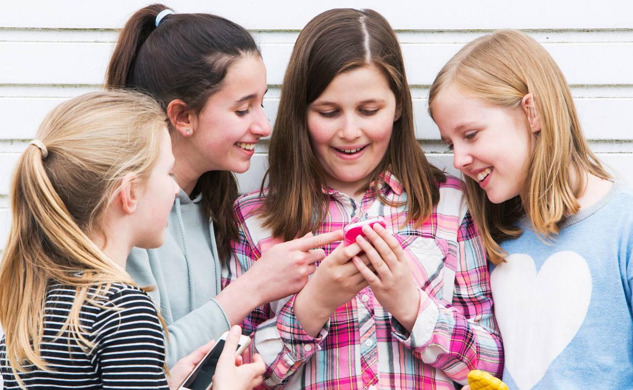 Grupo de jóvenes usando un teléfono móvil.