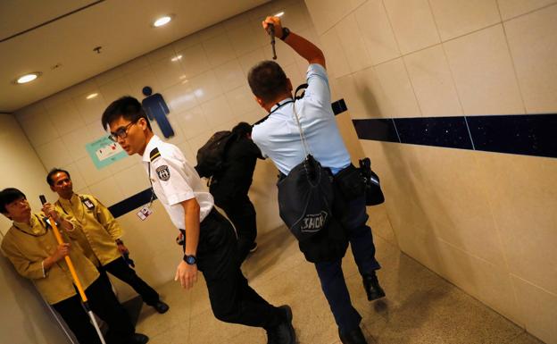 La policía persigue a un manifestante en el aeropuerto internacional de Hong Kong.
