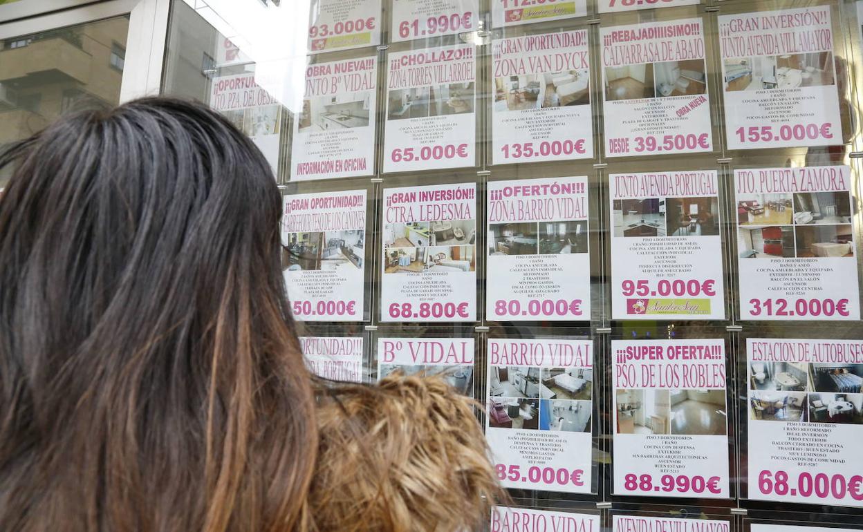 Una persona observa los anuncios de viviendas en el escaparate de una inmobiliaria de la ciudad de Salamanca.