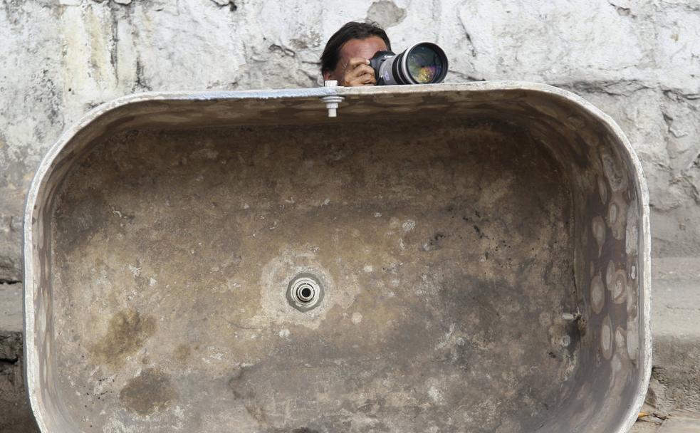 Un fotógrafo de Prensa se parapeta en una bañera durante una redada policial en una favela de Río de Janeiro.