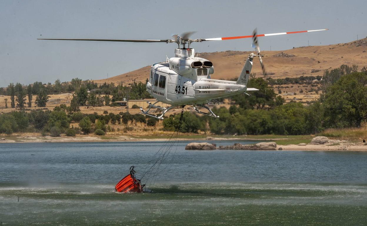 Un helicóptero recoge agua del Pontón durante el incendio en la sierra de Guadarrama del pasado 4 de agosto.