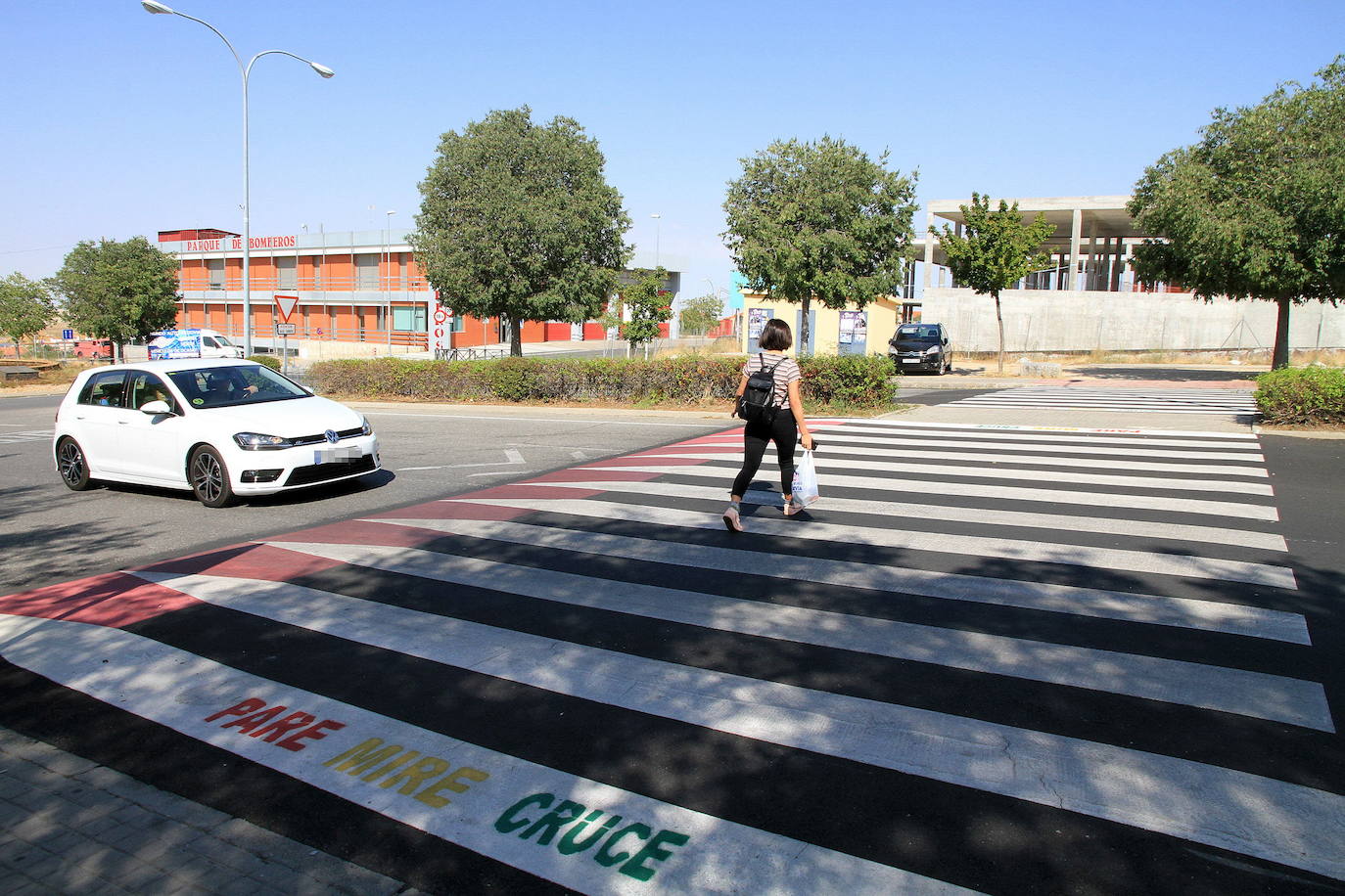 Una mujer cruza por un paso de peatones elevado de la ciudad.