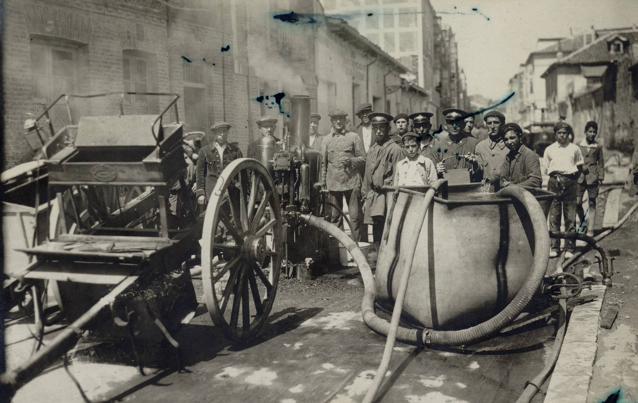 Agentes del servicio de extinción de incendios equipados con una bomba de vapor, depóstio de agua y carro de tracción animal.