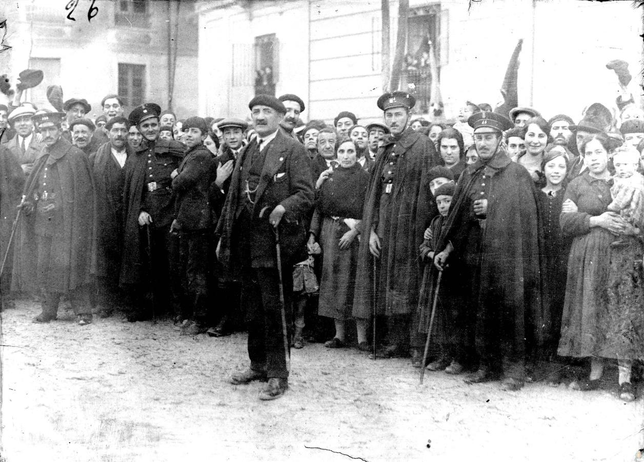 Agentes de la policía municipal rodeados de numerosas personas.