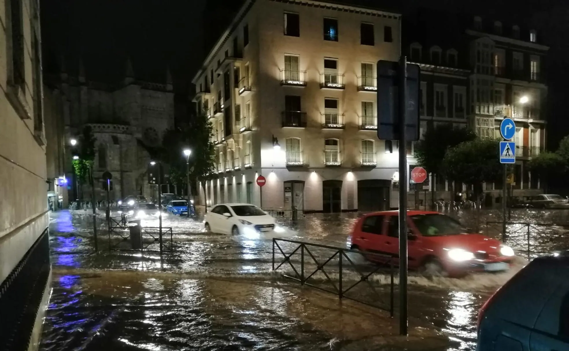 Varios coches circulan sobre balsas de agua en el centro de la ciudad.