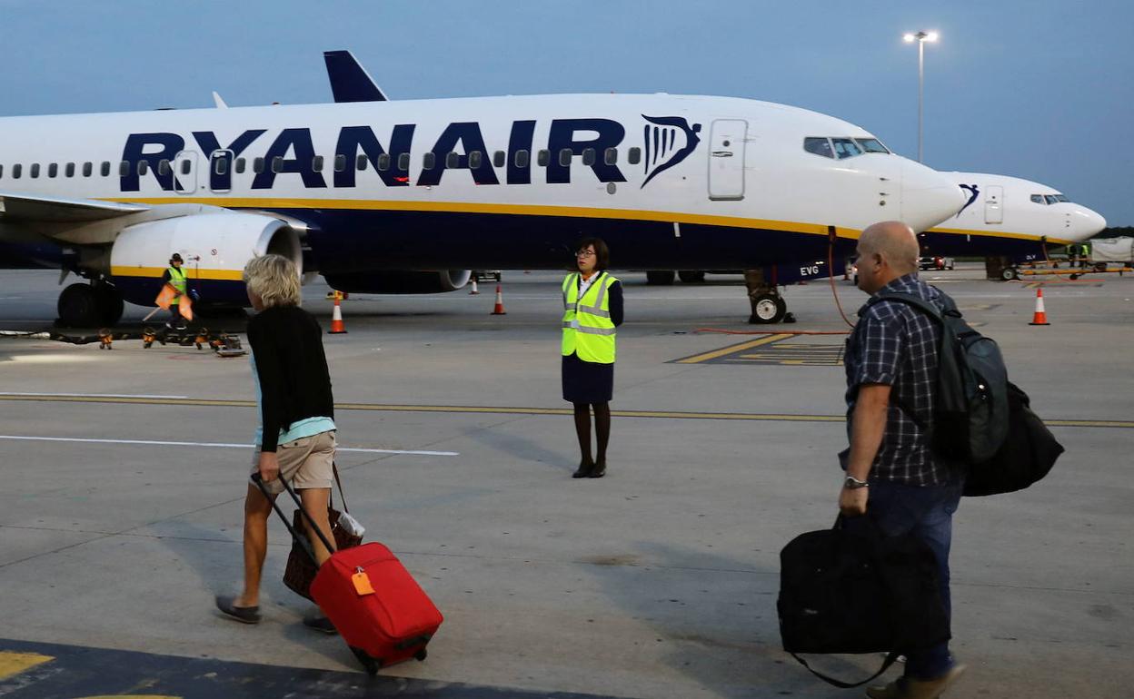 Varios pasajeros se dirigen hacia un avión de Ryanair. 