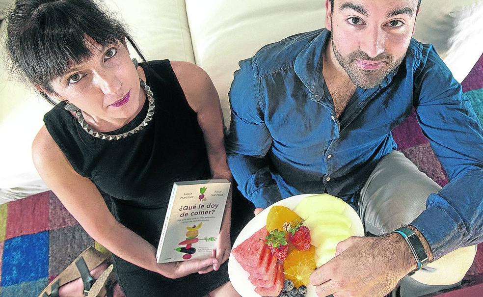 Los autores posan con su libro y un plato de fruta. 