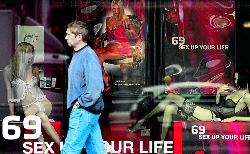 Un hombre pasea delante de un local dedicado al sexo.