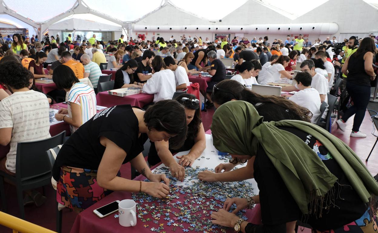 Cuatro chicas, concentradas, ordenan las piezas del rompecabezas. 