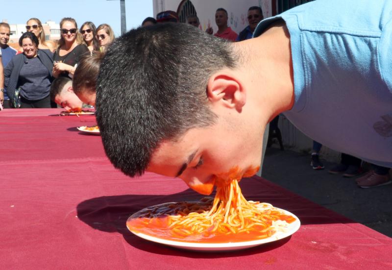 Participantes en el concurso de comer sin manos en el barrio de Pilarica de Valladolid.