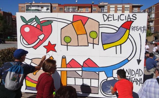 Los vecinos colaboran en el mural, diseñado por Manuel Sierra, para pedir la reapertura del centro de especialidades de Delicias