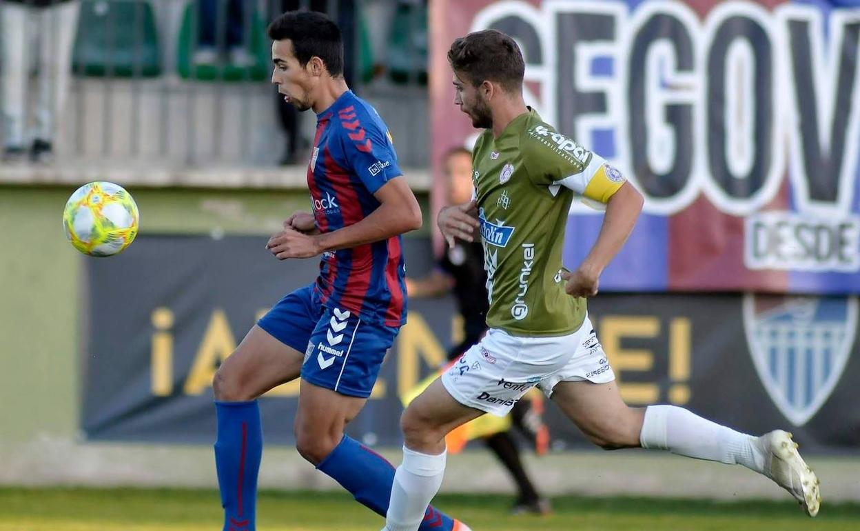 Diego Gómez persigue el balón ante un defensa del Cristo Atlético. 
