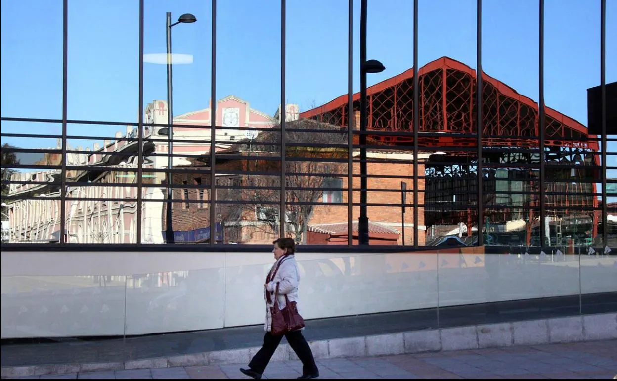 Una mujer camina junto a la estación de tren de León.