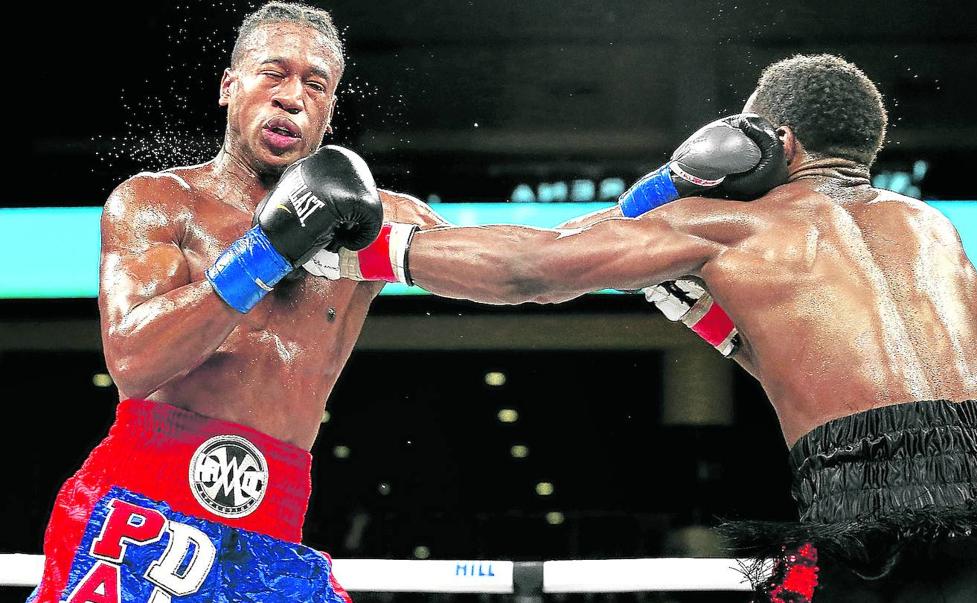 Patrick Day, a la izquierda, recibe un golpe de su rival, Charles Conwell.